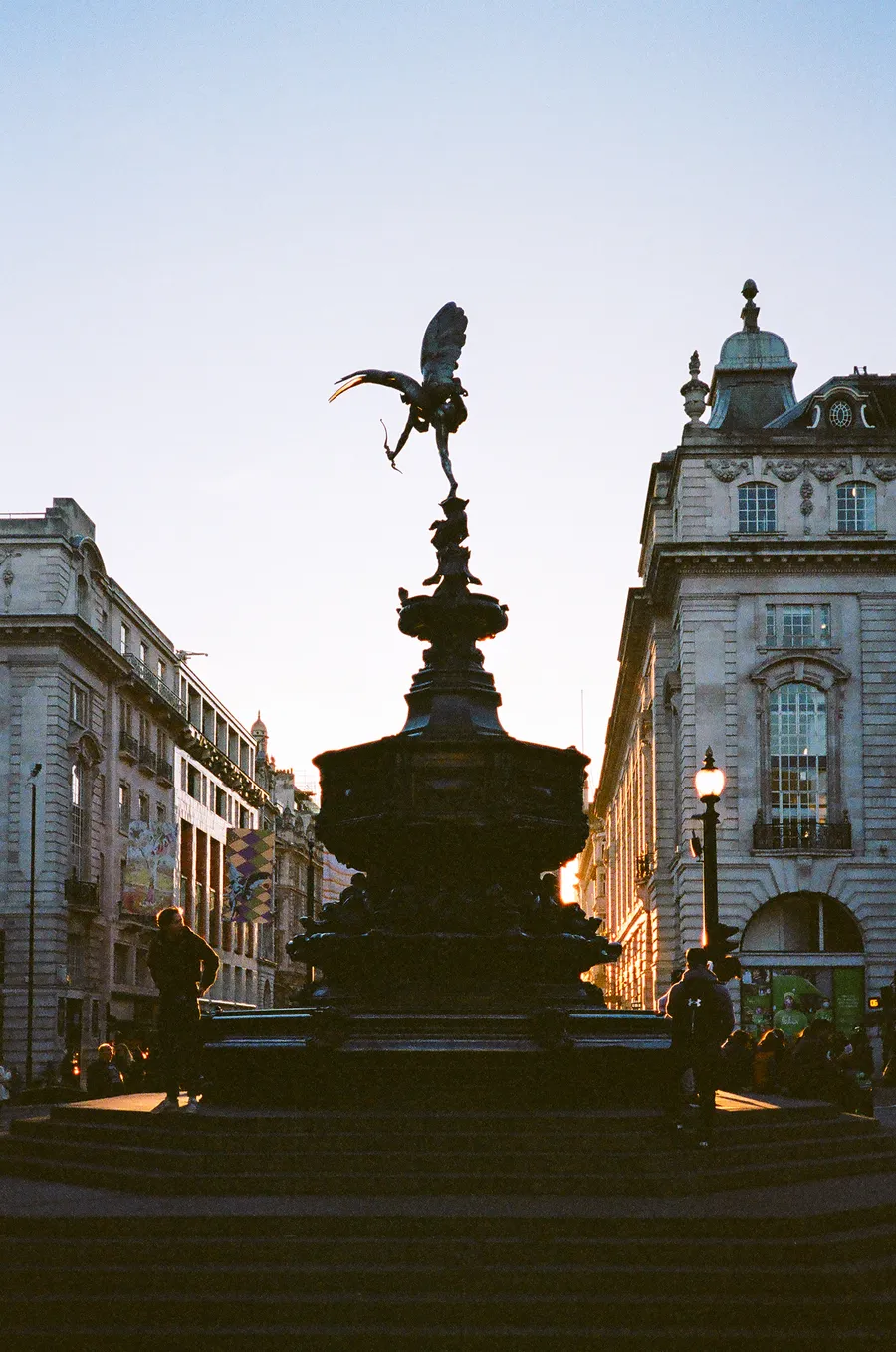 eros in silhouette against the last light, piccadilly circus, london